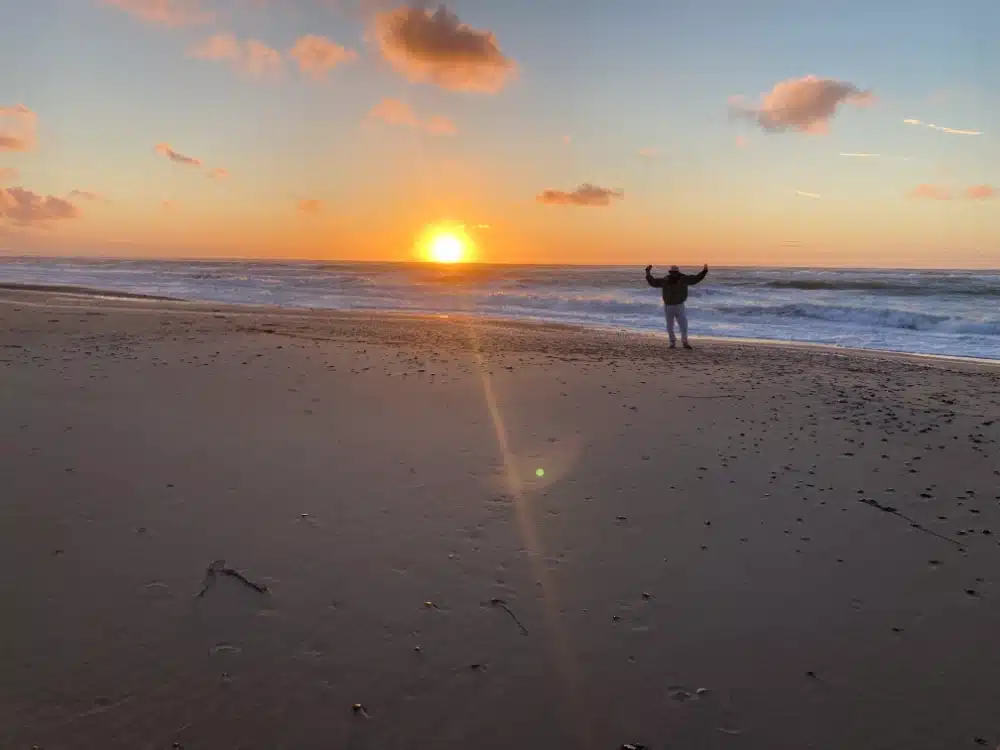 Person på stranden ved solnedgang – yoga hos Ankerplads
